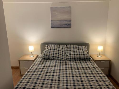 a bedroom with a bed with two lamps on night stands at Appartement - Proche CDG - Paris & Stade de France in Aubervilliers