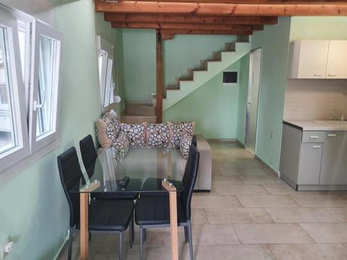 a dining room with a glass table and a staircase at Makis Nest Apart-Hotel in Vourvourou