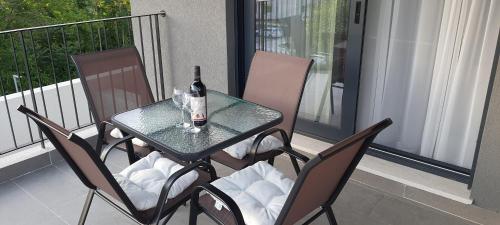 a table and chairs with a bottle of wine on a balcony at Luxury apartment Stefanija in Tivat