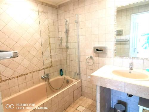 uma casa de banho com um chuveiro, uma banheira e um lavatório. em Appartement 16 en duplex, deux chambres - LES SUITES DE ROBINSON - Résidence avec piscine en bord de Siagne, à Mandelieu-La-Napoule em Mandelieu-la-Napoule