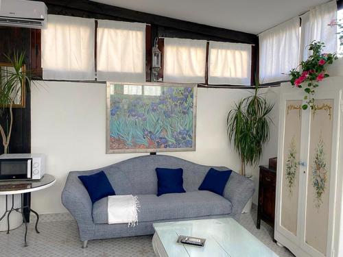 - un salon avec un canapé gris et des oreillers bleus dans l'établissement B&B Lido Liberty - "L'abbraccio di Klimt", à Lido di Ostia