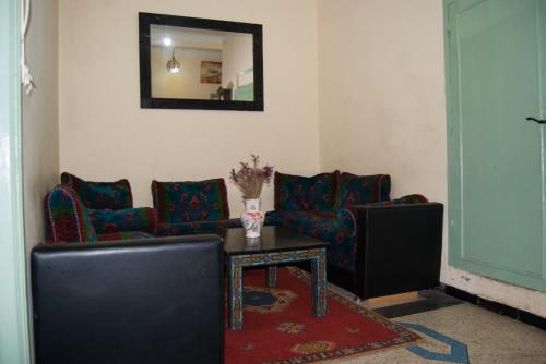 a living room with couches and a table and a mirror at Dar el Koutoubia in Marrakech