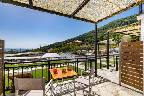 a patio with a table and chairs on a balcony at Panormos Beach Hotel Skopelos in Panormos Skopelos