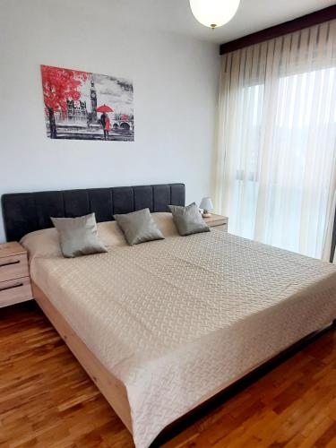 a bedroom with a large bed with white sheets at Apartman Peregrinus in Korenica