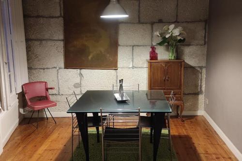 einen Esstisch mit Stühlen und eine Vase aus Blumen in der Unterkunft Acogedor apartamento en el Casco Antiguo in Vigo
