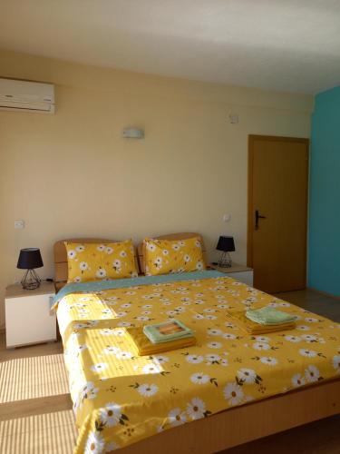 a bedroom with a bed with a yellow comforter at PS Apartments - Peshtani in Peštani