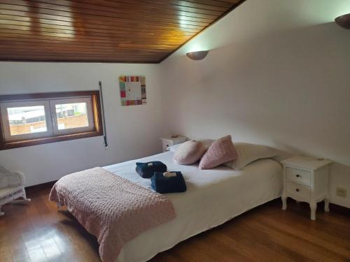 a bedroom with a bed with two bags on it at Casa Milia Orange in Marinhas