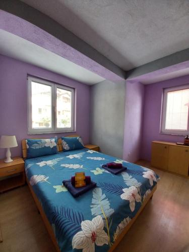 a bedroom with a blue bed with flowers on it at PS Apartments - Peshtani in Peštani