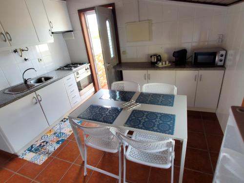 a kitchen with a table and chairs and a sink at Casa Milia Orange in Marinhas