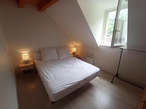a bedroom with a bed and two lamps on two tables at Le Therminus, T2Bis au cœur de Luchon in Luchon