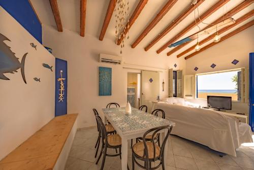 a living room with a table and chairs and a bed at Dimore di mare - Beachfront Apartments in Santa Flavia