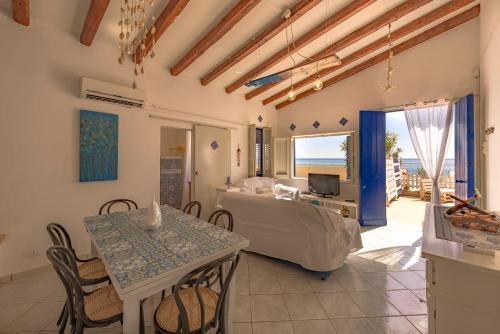 a living room with a bed and a table at Dimore di mare by Lisca Bianca Rental in Santa Flavia