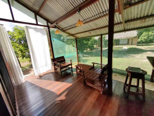 eine große abgeschirmte Veranda mit einem Tisch und Stühlen in der Unterkunft Albertico Jungle House in Pucallpa