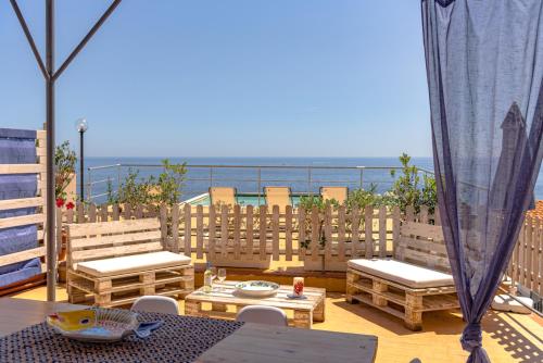 a patio with a table and chairs and the ocean at Dimore di mare - Beachfront Apartments in Santa Flavia