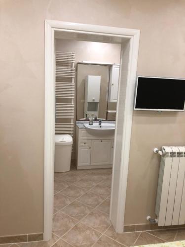a bathroom with a sink and a mirror and a toilet at Salento Appartamento Stella in Marina di Mancaversa