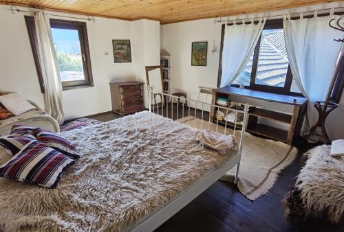 a bedroom with a bed and a desk and a piano at Guest house Smolyan in Smolyan