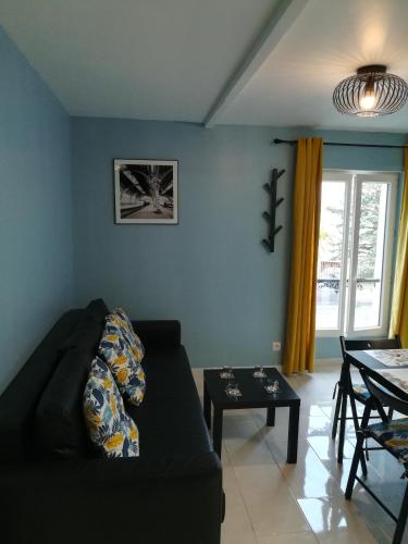 un salon avec un canapé noir et une table dans l'établissement Promotion du Jour - Le Figuier, à Deuil-la-Barre