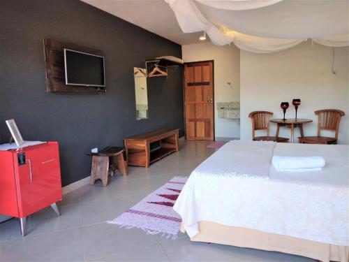 a bedroom with a bed and a tv on the wall at Pousada Zazen in Vale do Capao