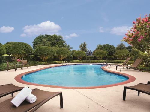 una gran piscina con bancos y árboles en Ameristar Casino Hotel Vicksburg, Ms. en Vicksburg