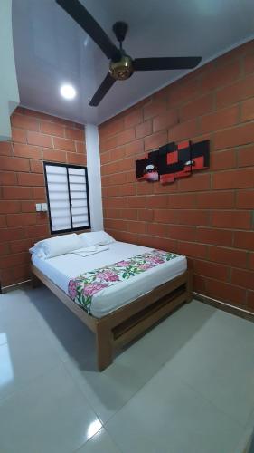 a bedroom with a bed in a brick wall at Hotel Cabañas Mar Caribe in Necoclí
