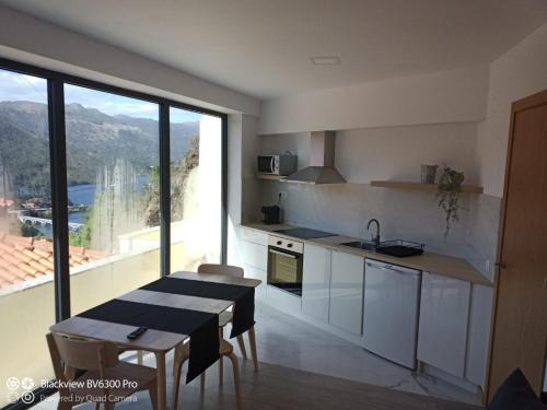a kitchen with a table and a kitchen with a view at Sabeni House in Vieira do Minho