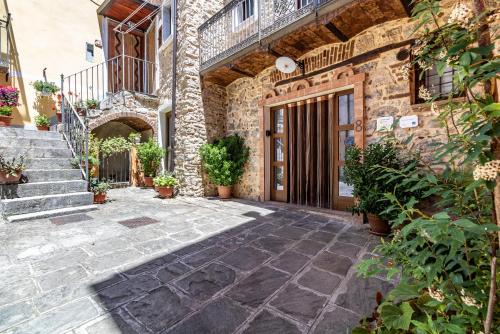 uma entrada para um edifício de pedra com escadas e vasos de plantas em Casa Vacanze 'Zia Lucia' em Sarconi