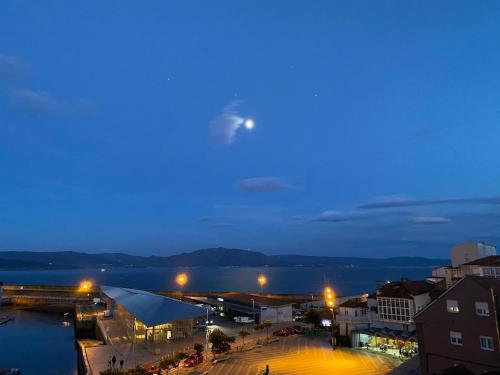 a view of a city at night with the moon at Casa Real 43 in Finisterre