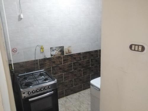 a small kitchen with a stove and a toilet at شقة فندقية - برج نجمة القصر in Marsa Matruh