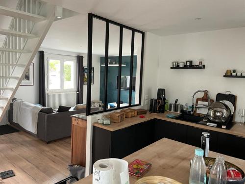 une cuisine et un salon avec un canapé dans l'établissement Grande maison au calme proche plage., à La Baule