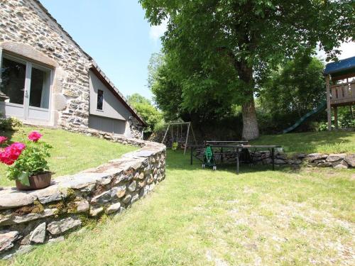 a yard with a stone wall and a picnic table at Gîte familial restauré avec jardin clos, équipements bébé, animaux acceptés, proche St-Julien-Chapteuil - FR-1-582-296 in Saint-Julien-Chapteuil