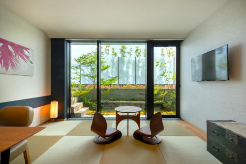 a room with a table and chairs and a large window at Genji Kyoto, a Member of Design Hotels in Kyoto
