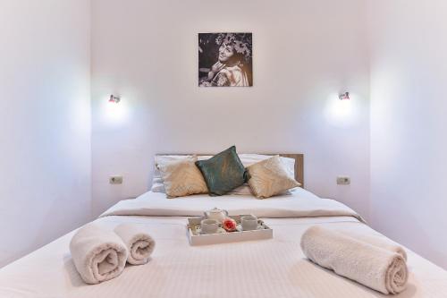 Arvala Lux Apartments في بودفا: سرير عليه مناشف وصينية اكل