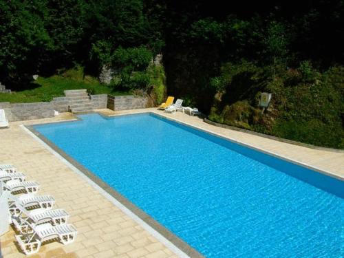 uma grande piscina azul com espreguiçadeiras ao lado em Hotel Universal no Gerês