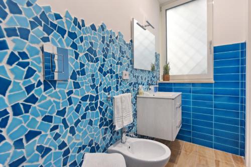a bathroom with a toilet and a blue tile wall at A' Treglia B&B in Santa Maria di Castellabate
