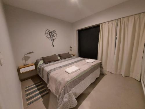 a bedroom with a large bed and a window at EXCEPCIONAL DEPARTAMENTO EN MAIPÚ- Ruta del vino 4 personas!! in Maipú