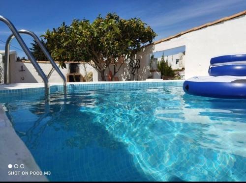 una gran piscina de agua azul frente a un edificio en Casa del abuelo antonioTrujillo en Conil de la Frontera