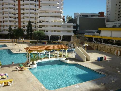 a large swimming pool in a city with buildings at Praia da Rocha - Charming Guest House in Portimão