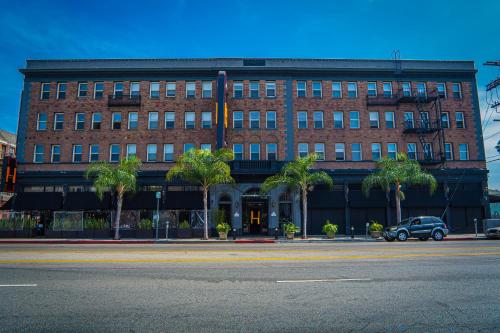 a large brick building with a car parked in front of it at H by H Hospitality in Los Angeles