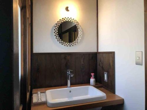 a bathroom with a sink and a mirror on the wall at 越中城端　荒町庵 in Nanto