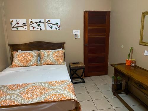 a bedroom with a bed and a dresser in it at City Garden Apartment in Belize City