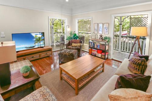 a living room with a table and a tv at Stoney Creek Cottage in Caravonica