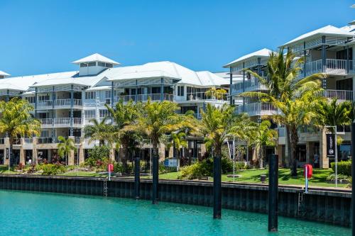 a row of palm trees in front of a building at The Boathouse Apartments in Airlie Beach