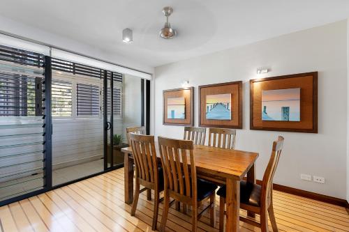 a dining room with a wooden table and chairs at The Boathouse Apartments in Airlie Beach