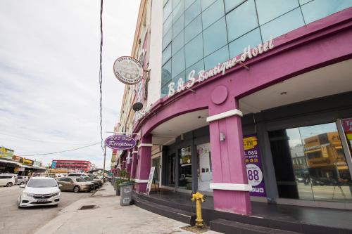 B&S Boutique Hotel في باتو باهات: مبنى وردي على جانب شارع