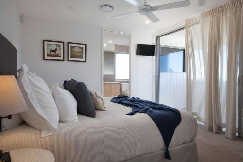 Un dormitorio con una cama con almohadas y una ventana. en Coolum Beach Holiday House, en Coolum Beach