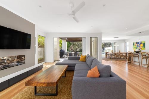 a living room with a couch and a table at Seaside Beach House in Marcoola