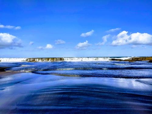 a body of water with a waterfall in the background at Pontal dos Sonhos- Chalés Praia do Farol in Coruripe