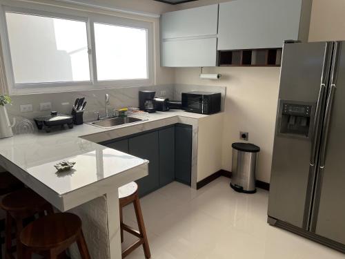 a kitchen with a refrigerator and a counter top at Fully equipped and furnished apartment and office in Guadalupe