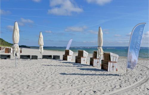 eine Gruppe von Sonnenschirmen und Stühlen am Strand in der Unterkunft Baltic in Binz