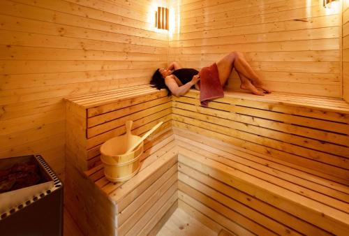 a woman sitting on a wooden bench in a bathroom at Solneset Farm in Bergen